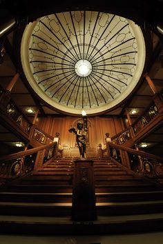 the inside of a building with stairs and a domed ceiling above it is lit by lights