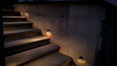 some lights that are on the side of stairs