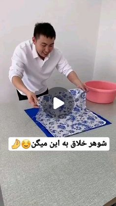 a man is cutting up a blue and white plate on a table with a pink bowl in the background