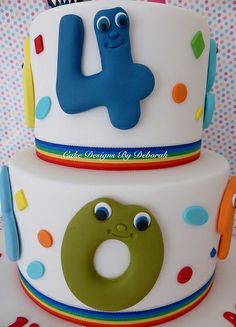 two tiered birthday cake decorated with fondant numbers and colorful polka dot decorations, including a pretzel