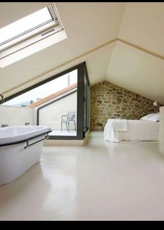 a bathroom with a skylight above it and a bathtub in the middle of the room