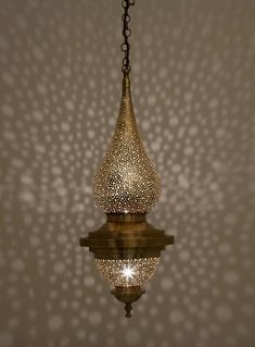 a chandelier hanging from the ceiling in front of a wall with dots on it