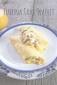 a white plate topped with an omelet next to a glass of orange juice