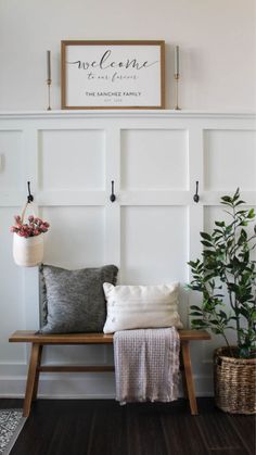 a bench with some pillows on it next to a potted plant and a sign