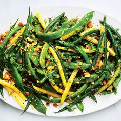 a white plate topped with green beans and yellow peppers