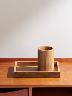 a wooden cup sitting on top of a wooden tray