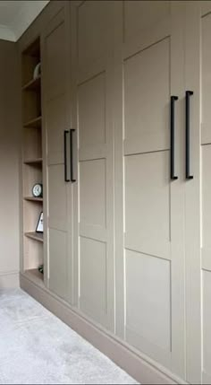 a room that has some shelves and cabinets in it with white carpet on the floor