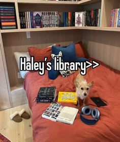 a dog sitting on top of a bed next to a book shelf filled with books