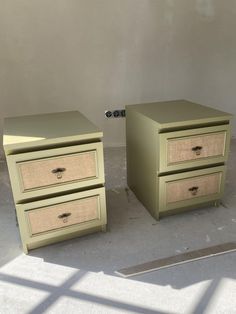 two green nightstands sitting next to each other on top of a cement floor in front of a white wall