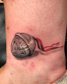 a tattoo on the leg of a woman with a red ribbon coming out of it