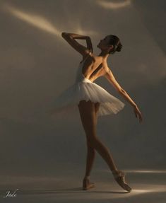 a ballerina in white tutu and ballet shoes posing for the camera with her arms behind her head