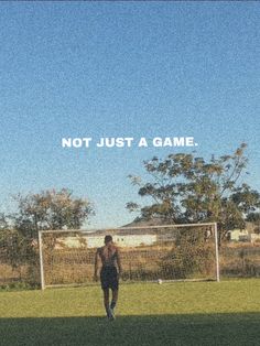 a man standing on top of a lush green field next to a soccer ball under a blue sky