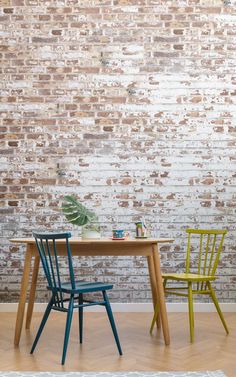 two chairs and a table in front of a brick wall