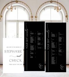 two black and white wedding program stands next to each other in front of large windows