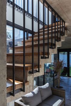 a couch sitting under a stair case next to a set of wooden banisters