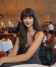 a woman sitting at a table in a restaurant