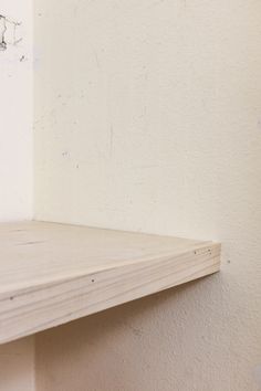 an empty shelf in the corner of a room