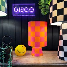 two lamps and a smiley face sitting on a table in front of a disco sign