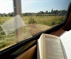 an open book sitting on top of a train window