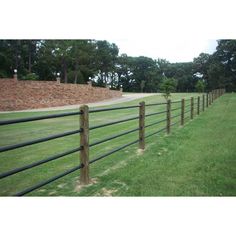 a long fence in the middle of a grassy field