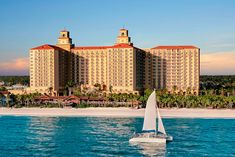 a sailboat on the water in front of a hotel