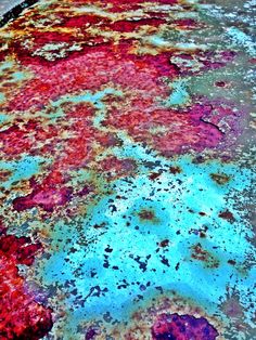 an old rusted surface with blue and red paint