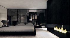 a modern bedroom with a fireplace in the center and black walls, along with white bedding