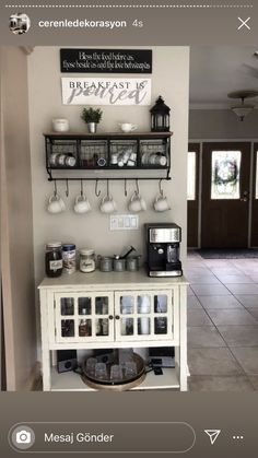 a coffee bar with several cups on the top and two shelves above it that hold drinks