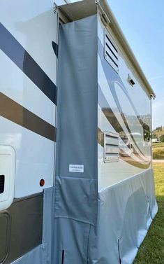 an rv is parked on the grass with it's cover pulled over to protect it from the sun