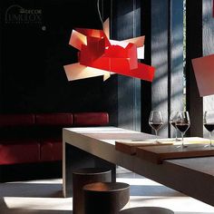 a table with some wine glasses on it and a red lamp hanging from the ceiling