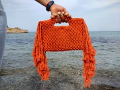 "Macrame Orange Fringed Wooden Beaded Bag, Clutch bag ,Handmade Bag ,Summer Mini Bag ,Macrame Small bag ,Christmas gift ,Tassel bag This macrame bag is made of 100% cotton yarn and is completely hand knitted. There are cute tassels on the sides of the bag. I created this awesome but cute orange wooden beaded hand knotted summer bag macrame clutch with love..You can use this gorgeous bag for your smartphone,small wallets and for your cocmetics. The style of this macrame bag  will blend seamlessly with your outfit for a modern look. You can also buy this cute macrame bag for yourself if you wish. If you wish, you can buy it as a housewarming gift, a birthday gift, a mother's day gift, a new year gift to your loved ones, and a perfect gift for your friends and bridesmaids. Created with 100% c Macrame Tas, Bag Macrame, Macrame Purse, Crochet Pillow Cover, Chunky Knit Throw, Fringe Bags, Bag Summer, Beaded Bag, Macrame Bag