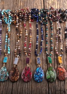 a group of necklaces sitting on top of a wooden table next to each other