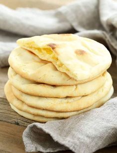 a stack of flatbreads sitting on top of a wooden table next to a napkin