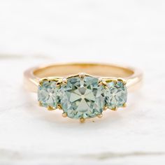 three stone ring sitting on top of a marble surface