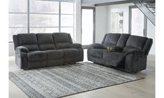 two reclining sofas sitting on top of a rug