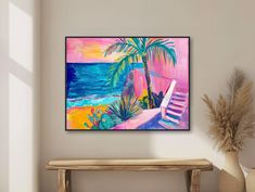 a painting is hanging on the wall above a bench with a potted palm tree