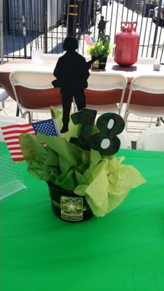 a green table topped with a potted plant next to a sign that says 8