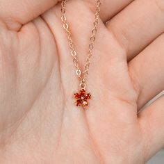 Sunlit Blossom Necklace features a sweet orangey red crystal flower pendant. Picture the intense glow of a sunset, where the sun bathes the sky in a rich combination of fiery oranges and deep reds. The color of this crystal pendant shows love and passion, making it great for any time you want to feel special. • 14K Gold-Filled. • Faceted red crystal. Elegant Orange Crystal Necklace As A Gift, Elegant Orange Crystal Necklace For Gift, Orange Pendant Necklace With Birthstone, Orange Birthstone Pendant Necklace, Orange Birthstone Necklace As Gift, Orange Birthstone Necklace Gift, Orange Flower Pendant Jewelry For Gift, Orange Flower Pendant Jewelry Gift, Orange Flower Pendant Necklace For Gift