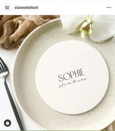 a white plate with the word sophiie on it next to a fork and flower