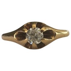 an old fashioned diamond ring with a flower design on the side and a single stone in the center