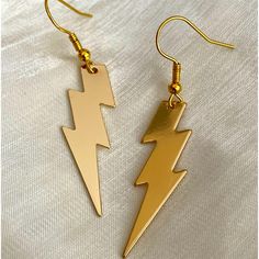 pair of gold earrings with lightning design on them