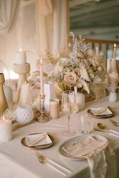 the table is set with place settings and candles