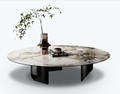 a round marble table with a vase on top and a book next to it, in front of a white background