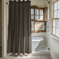 a bathroom with a shower curtain, tub and window in it's center area