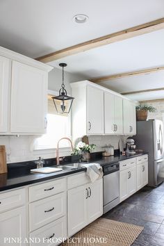 a kitchen with white cabinets and black counter tops