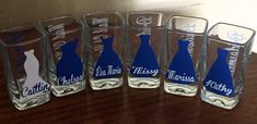 five personalized glass bottles sitting on top of a wooden table