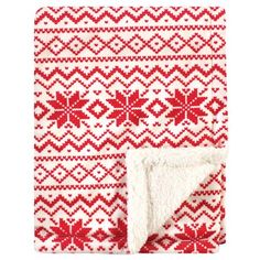 a red and white blanket with snowflakes on the bottom, in front of a white background