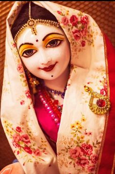 a close up of a person wearing a mask and headdress with flowers on it