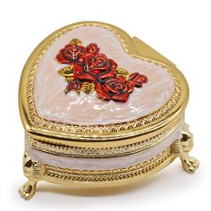 a heart shaped trinket box with roses on the lid and gold trimmings