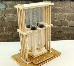 a miniature model of a building made out of wood and plastic tubes on a table